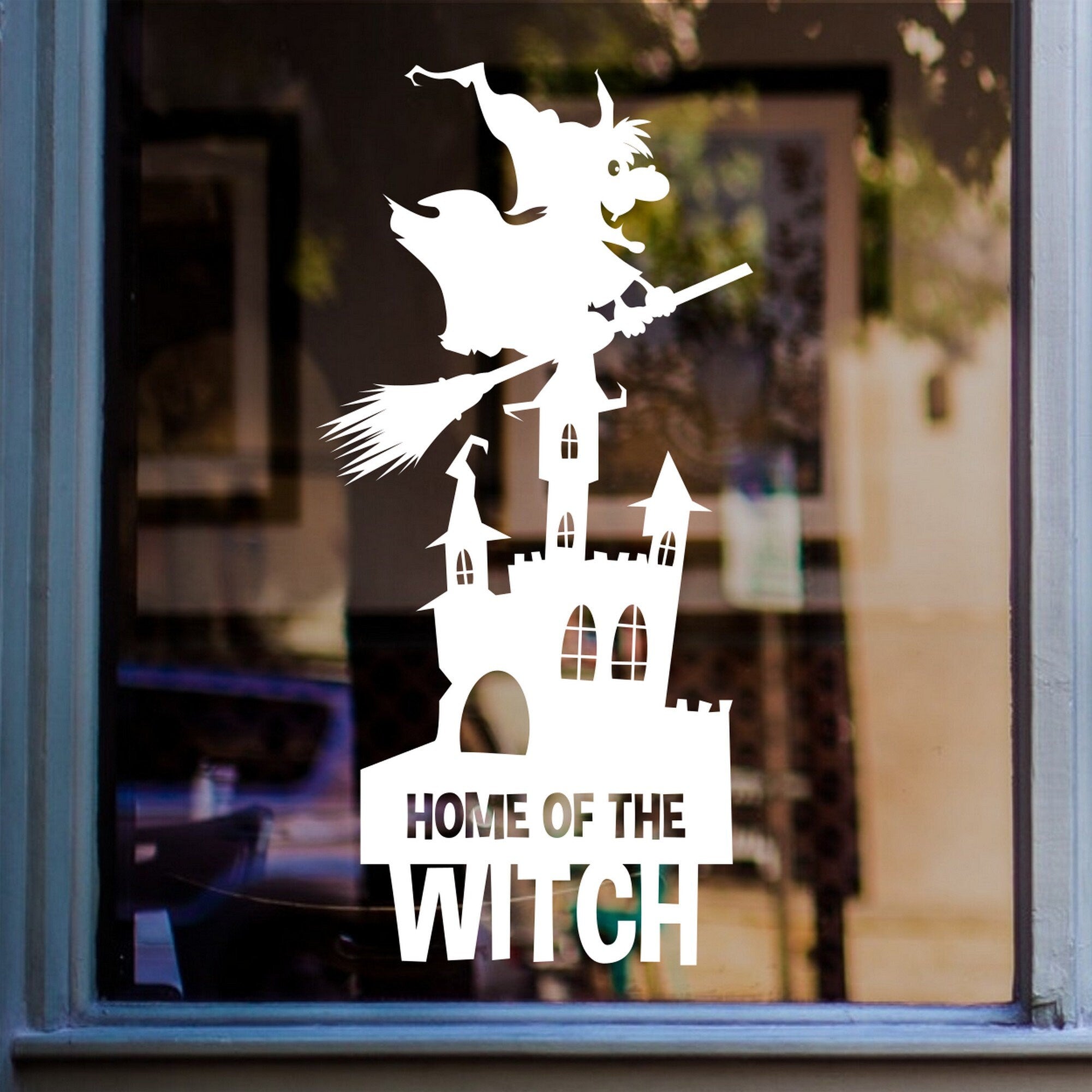 Home of the Witch Halloween Window Sticker shown on a shop window