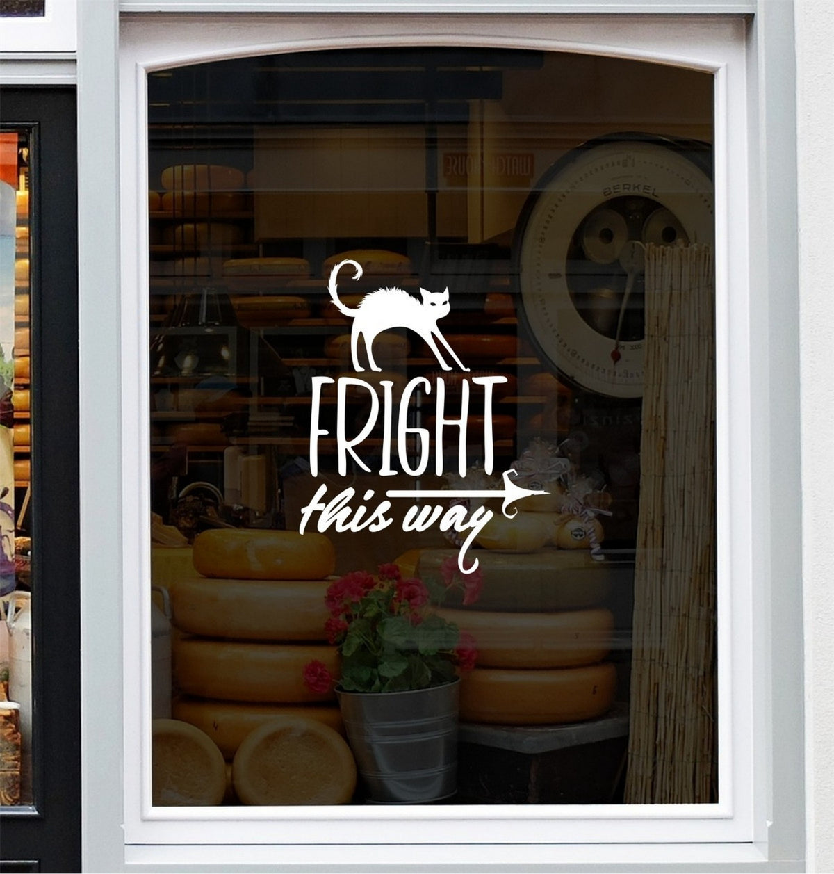 White Fright This Way Halloween sticker centred on a white-framed shop window.