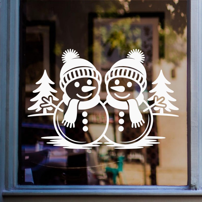Christmas snowmen window sticker featuring two festive snowmen with winter hats, scarves and fir trees on glass.