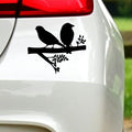 Black two birds on a branch sticker on white car bodywork beneath a rear light.