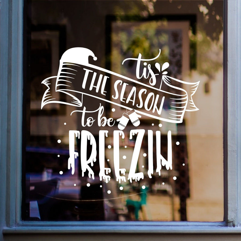 White Tis the Season to Be Freezin Christmas sticker on a cheese shop window