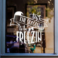 White Tis the Season to Be Freezin Christmas sticker on a cheese shop window